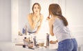 Amazing young woman doing her makeup in front of mirror. Portra