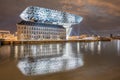 Amazing Zaha Hadid Port House Antwerp at night reflected in a canal Royalty Free Stock Photo