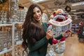 Amazingly beautiful, cheerful woman holding Happy holidays plush toy ornament