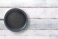 Amazon Alexa Echo Dot intelligent speaker controlled by voice, on a white wooden table. Empty copy space Royalty Free Stock Photo
