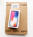 Amazon box and Apple iphone X10 against gray background
