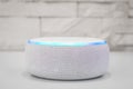 Amazon echo dot , Alexa voice controlled speaker with activated voice recognition, on brick and white background