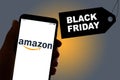 The Amazon shopping app logo is seen on the display of a smarthphone with a `Black Friday` sign in the background in Barcelona,