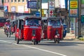 Two red tuk-tuks driving along a city street, Sri Lanka Royalty Free Stock Photo