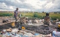 Ambatolampy, Madagascar - April 25, 2019: Unknown Malagasy man and woman working near simple fire oven, collecting scrap aluminium