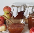 Amber apple jam in a salad bowl on a wooden table with jars of jam in the background. Season for making jam for future use Royalty Free Stock Photo