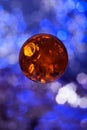 amber ball bead close-up against the background of blue bokeh lights