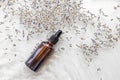 Amber bottle of lavender essential oil. Flat lay concept. Light background with water waves.