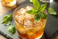 Amber Cocktail With Ice Cubes And Fresh Basil Leaves In Sharp Close Up View Royalty Free Stock Photo