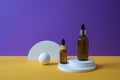 Amber glass dropper bottle with metallic lid on the white podium. Orange and purple background. Royalty Free Stock Photo