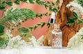 Amber glass dropper bottle of serum or oil in nature. Leaves and flowers on pink Royalty Free Stock Photo