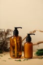 Amber glass pump dispenser bottles with natural shampoo and shower gel. Tree branch, bark birch, moss on background
