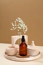 Amber glass spray cosmetic bottle and modern DIY concrete home decor on beige background