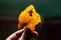 Amber in the hand. On a dark background. Close-up amber. Amber for advertising and sales. Colored stone.