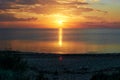 Amber sunset on the baltic sea. Calm sea, reflection of sun light in calm evening water. fiery sunset and calm clouds in the sky