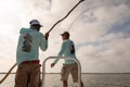 A fishing guide instructs a fly fisherman on bonefishing technique in Belize, Central America