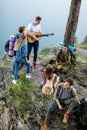 Ambitious active travellers playing the guitar, singing songs in the fresh air