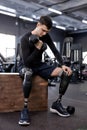 ambitious active young man in stylish sportswear doing exercises with dumbbells