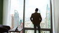 Ambitious businessman standing in ornamented office on cityscappe background