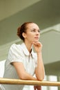 Ambitious businesswoman looking away in thought. Portrait of young businesswoman leaning on railing and looking away at