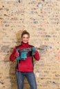 Ambitious craftswoman with caulking hammer in front of brick wall in bare brickwork Royalty Free Stock Photo