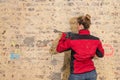 Ambitious craftswoman with caulking hammer in front of brick wall in bare brickwork Royalty Free Stock Photo