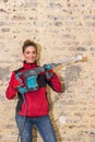 Ambitious craftswoman with caulking hammer in front of brick wall in bare brickwork Royalty Free Stock Photo