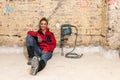 Ambitious craftswoman sitting on floor in front of brick wall in Royalty Free Stock Photo