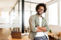 Ambitious highly-skilled handsome curly african-american male employee leaned on office desk and looking at the camera Royalty Free Stock Photo