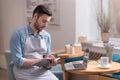 Ambitious man sitting on an armchair and making notes. Royalty Free Stock Photo