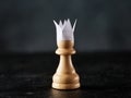 Ambitious pawn with paper crown aspires to be a king