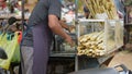 ambodian man extracting sugar cane juice using machine on the street