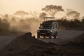 Safari Land Cruiser vehicle drives on the dusty roads at sunset