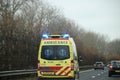 Ambulance with blue flashing lights and sirens on motorway A44 in the Netherlands.