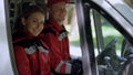 Ambulance crew looking into camera, sitting in transport, emergency services