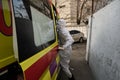 An ambulance doctor in a special suit gets into the car. Almaty city