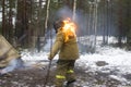 Ambulance drills in the winter forest. The woman stuntman caught fire from the fire and flees. Rescuers will have to Royalty Free Stock Photo