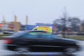 The ambulance drives on the street at high speed during heavy traffic. Blurred car in the foreground. Motion blur. Riga, Latvia -