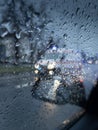 Ambulance in foreground with rain drops in focus photographed from a car while waiting in traffic. Moody vibes.