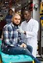 Ambulance team providing medical care to injured male patient in ambulance car Royalty Free Stock Photo