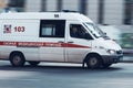 ambulance van in motion driving down city road. Special car of paramedic emergency riding through street on high speed Royalty Free Stock Photo