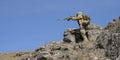 Ambush in the mountains - special forces professional sniper aiming at the enemy in the mountains. Royalty Free Stock Photo