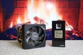 AMD Ryzen 7 3700X CPU processor unit next to its big Wraith Prism cooler. Fireplace in the background Royalty Free Stock Photo