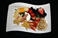 Closeup of a display of assorted fresh and dried fruits, cheeses, berries and nuts