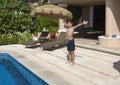 Amerasian boy preparing to jump in swimming pool