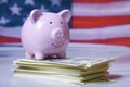 America economics, budget, saving and investment concept. Piggy bank and US Dollars against United States national flag as symbol Royalty Free Stock Photo