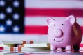 America economics, budget, saving and investment concept. Pink piggy bank and US Dollar stacks against United States national flag Royalty Free Stock Photo