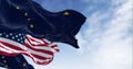 American and Alaskan flags wave in the wind against a blue sky Royalty Free Stock Photo