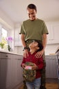 American Army Mother In Uniform Home On Leave With Son Holding Her Cap In Family Kitchen Royalty Free Stock Photo