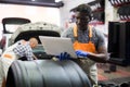 African mechanic man using a laptop computer checking car in workshop Royalty Free Stock Photo